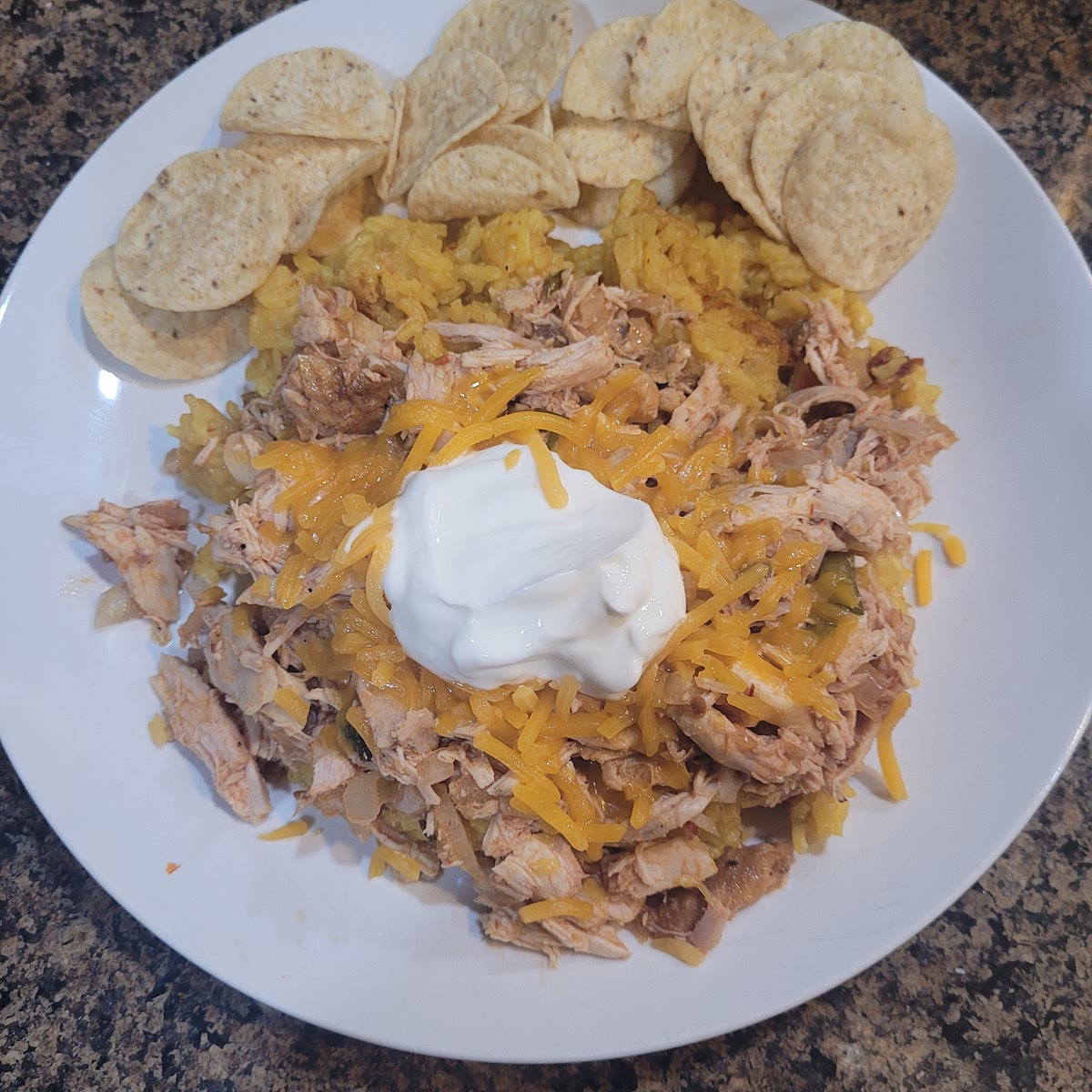 Plate with rice first, then chicken mixture and top with cheese, sour cream and chips.