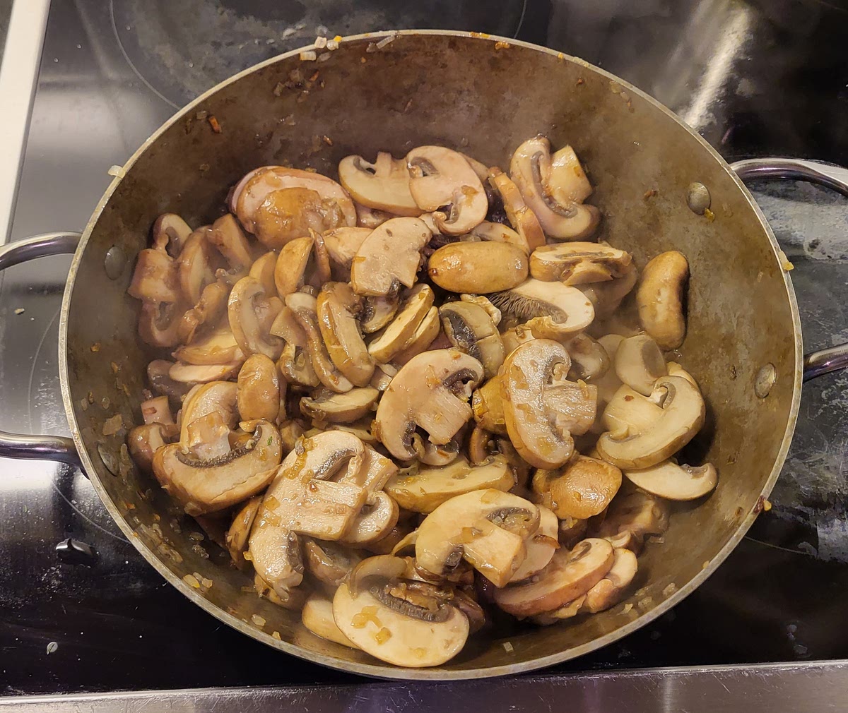 Doe een scheutje olijfolie in een pan. Fruit de sjalotten totdat ze lichtbruin kleuren. Voeg hierna de kastanjechampignons toe en bak goed door