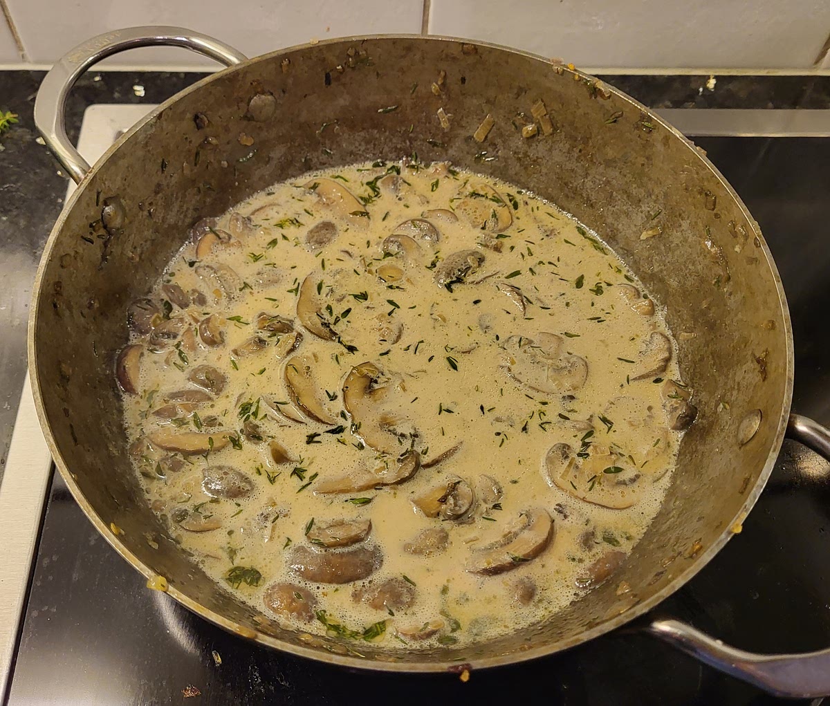 Voeg de witte wijn toe bij de kastanjechampignons. Laat het reduceren tot er nog maar een klein laagje vocht in de pan zit. Voeg vervolgens de slagroom en de truffeltapenade toe. Laat de saus rustig pruttelen op laag vuur.