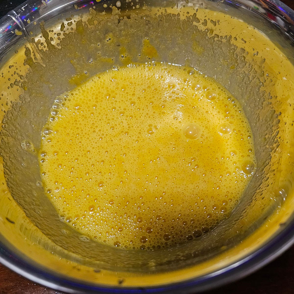 Next we're preparing the eggs. You are able to skip this step if you trust youre eggs, or if you're using already pasturized yolks; however, we are going to pasturize the eggs. You're going to want to get a small pot of boiling water going. Such that the metal bowl you're using to whisk them will fit in the pot without touching the water. Take the sugar, egg yolks, and water, add them to the bowl and *continuously whisk* them until its reached a temp of 165 °F. The attached picture shows what the eggs should look like before starting. Do not scramble the eggs!