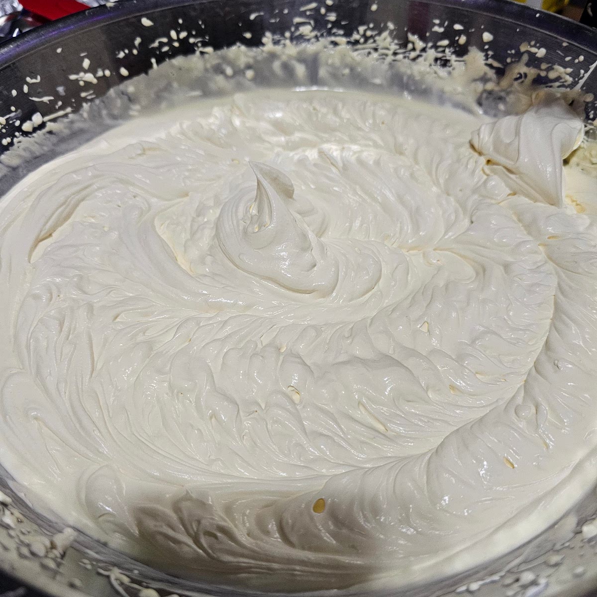 Finally, take the cream mixture out of the refrigerator, and combine it *carefully* with the egg mixture. You will need a larger bowl than it looks, this mixture will increase in size. Whip the mixture together until you have stiff peaks again. The mixture needs to be able to stand up straight on its own or the slices of Tiramisu will fall over. See picture.