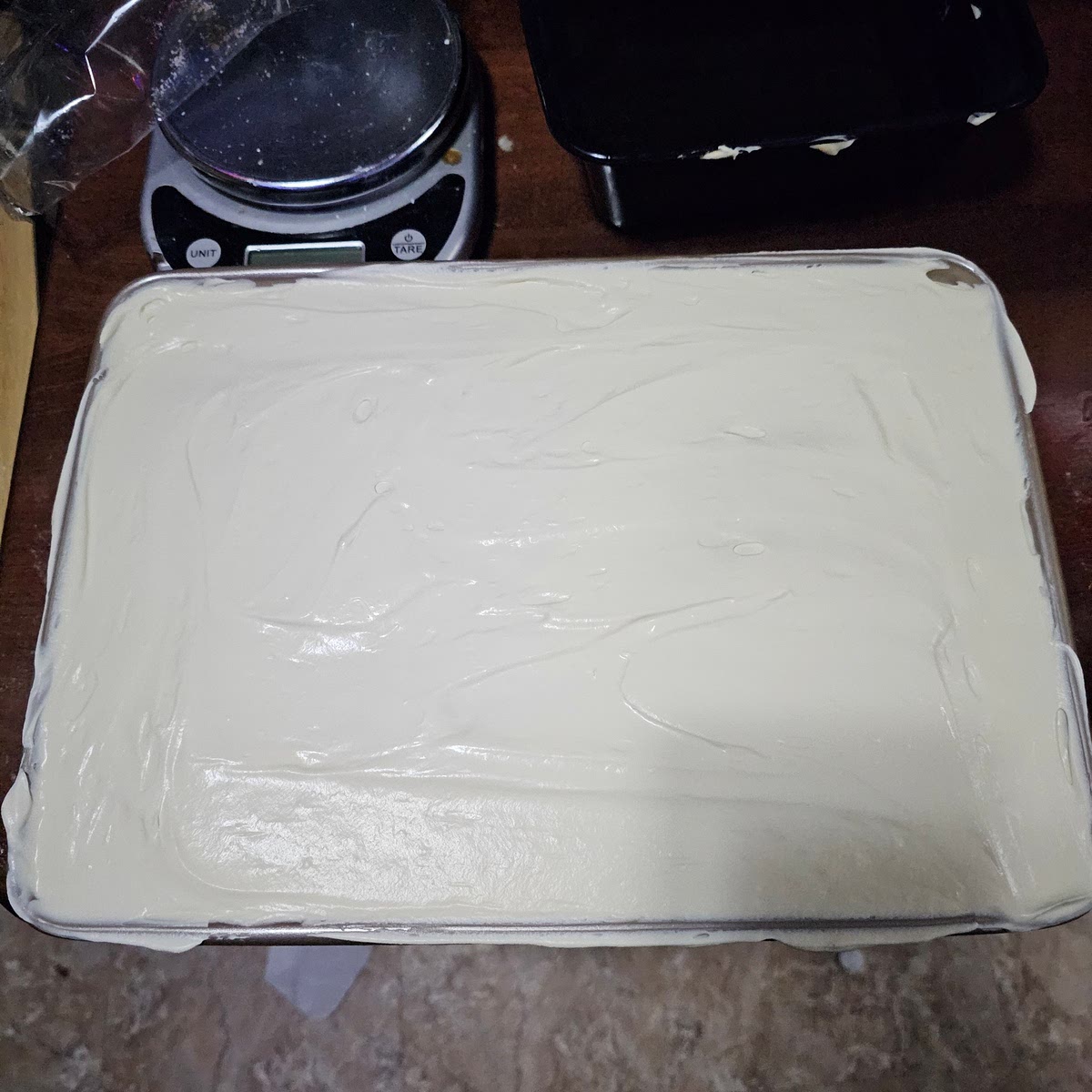 Finally add the rest of the cream mixture to fill the pan to the top. These cakes are typically rather tall. You do not want to add the powered sugar or coco powder on top until you're ready to serve. Wrap air tight and refrigerate for at least an hour, ideally two or three hours.