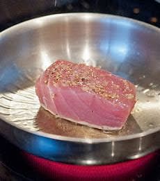Simmer sliced tuna in a non stick pan, cover and let it cook for about 15 minutes in above medium fire, when done add coconut milk (optional) and cocoa powder avoid too low water content or too sticky sauce so adjust fire and mixture of water and cocoa power.