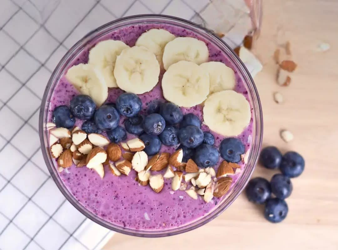 Mandeldrink, gefrorene Blaubeeren, Naturjoghurt und die Eiswürfel in einen Mixer geben und diesen für 1 Minute auf die höchste Stufe stellen.