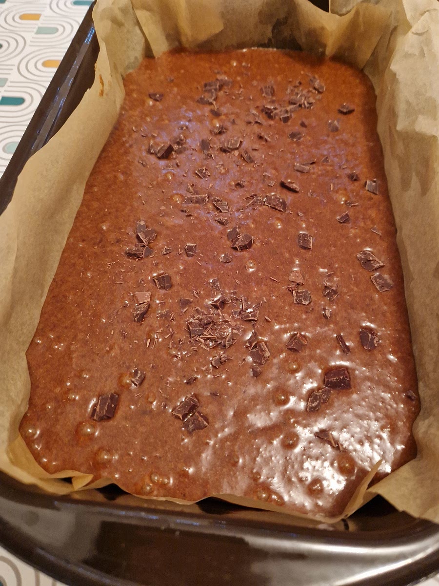 Pour mixture into your baking pan roughly 30x10 cm, level it using your spatula and sprinkle a fistful of chopped chocolate on top of the mixture