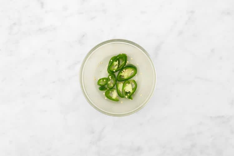 Heize den Backofen auf 220 °C Ober-/Unterhitze (200 °C Umluft) vor. Erhitze 50 ml [75 ml | 100 ml] Wasser im Wasserkocher. Limette vierteln. Jalapeños nach Belieben entkernen (Achtung: scharf!) und in feine Streifen schneiden. In einer kleinen Schüssel 50 ml [75 ml | 100 ml] heißes Wasser*, Saft von 2 [3 | 4] Limettenvierteln, 0,5 TL [0,75 TL | 1 TL] Salz* und 0,5 TL [0,75 TL | 1 TL] Zucker* vermengen. Jalapeños hinzugeben und bis zum Ende des Rezeptes marinieren lassen.