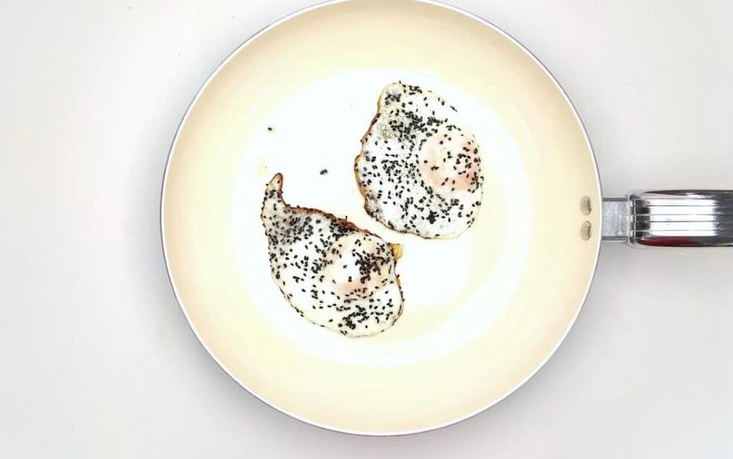 Once hot, add half your nigella seeds, then crack the reserved egg[s] into the pan and sprinkle the remaining nigella seeds over the top with a pinch of salt