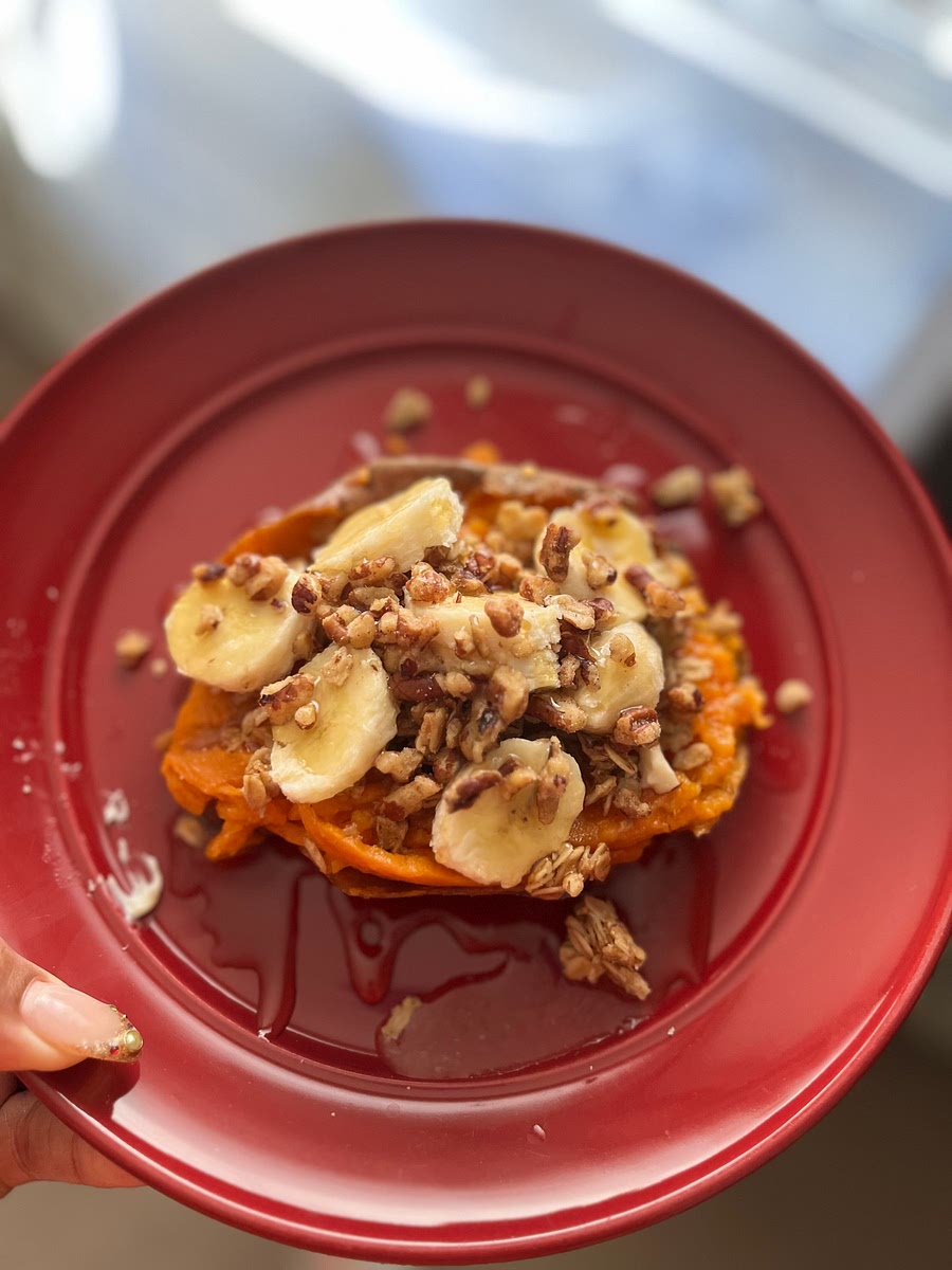 A bake your sweet potato. Me personally I used a microwave one.
Microwaved my potato for 8 mins
Cut open the potato and add your butter then your granola and banana Spread the honey all Over that bad boy!!!