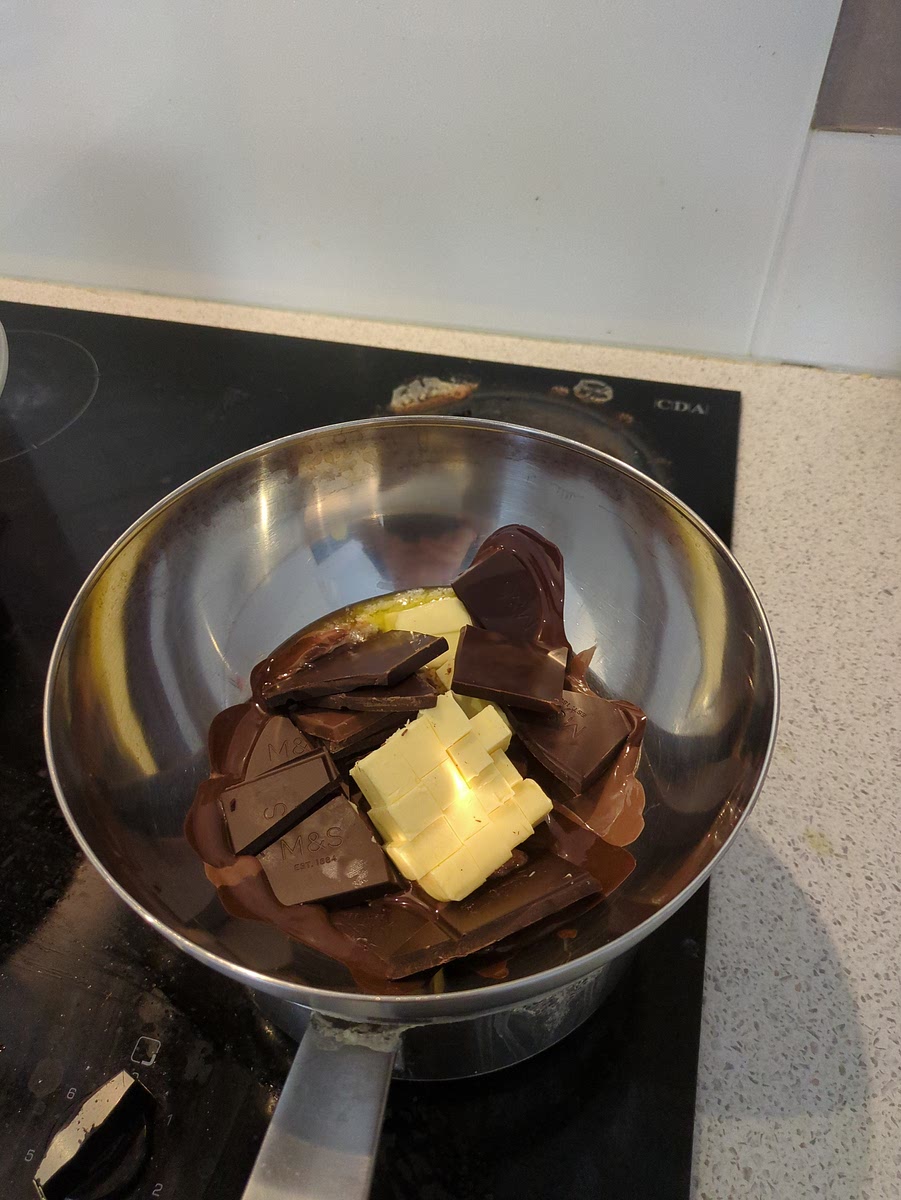 Sciogli cioccolato e burro a bagno maria, lascia raffreddare.