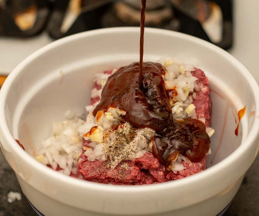 Finely mince the onion and garlic. Place the ground buffalo in a bowl with the onion, garlic, smoked paprika, salt, and pepper. Mix in the Worcestershire and BBQ sauces.