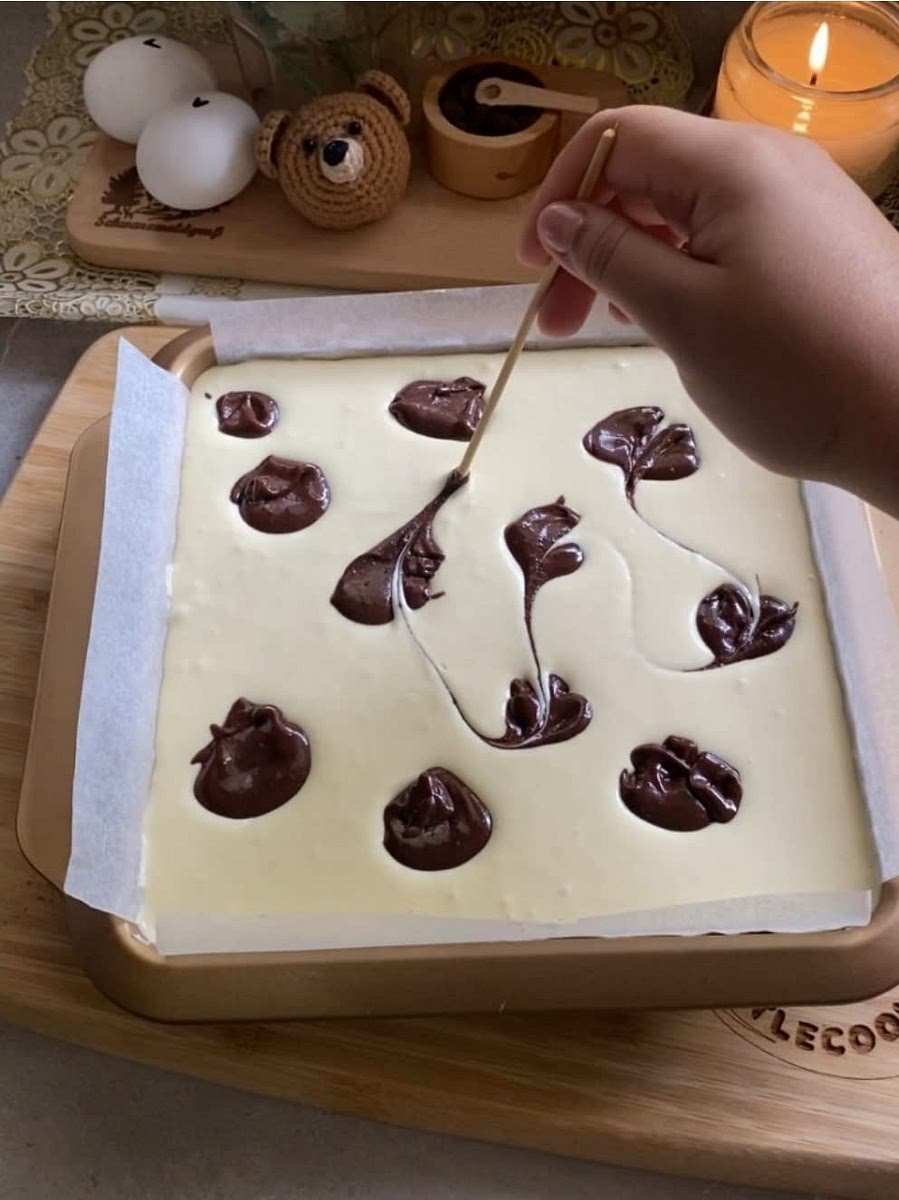 Mezclar el apartado de mezcla de brownie que teniamos con un poco de agua caliente. Esto es para que la mezcla del brownie este mas manejable para hacer la decoracion. Agregar unos pequeños circulos de masa de brownie.