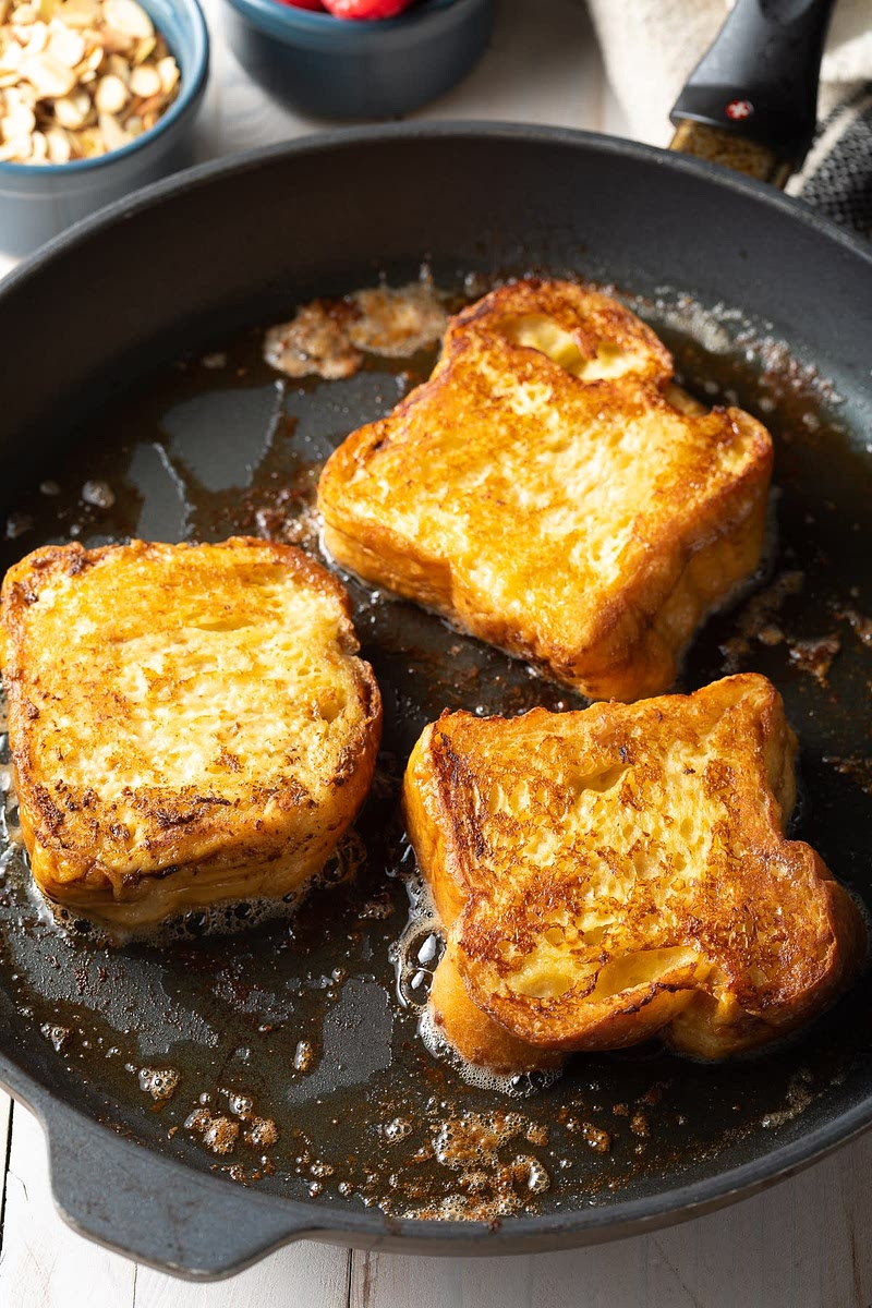 To cook dip both sides of a slice of bread into your butter and lay it on the prepared pan away from you only slip when you stop seeing bubbling on the sides of the test and I pan when golden Brown and both sides remove and repeat for the rest of the slices.