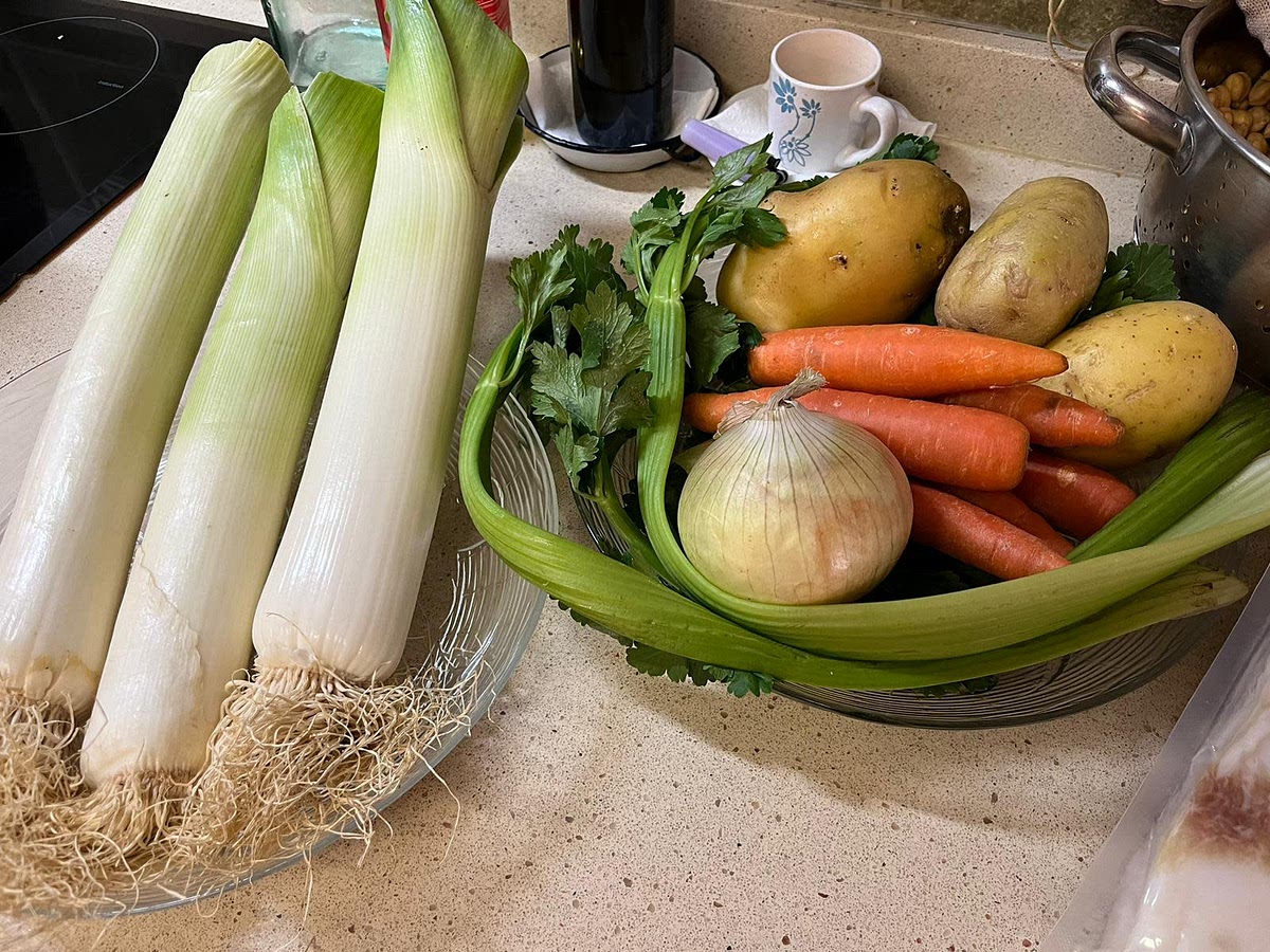 A las tres horas, echamos la verdura pelada y lavada y los chorizos. Es el mento de echar el puerro que hemos guardado.