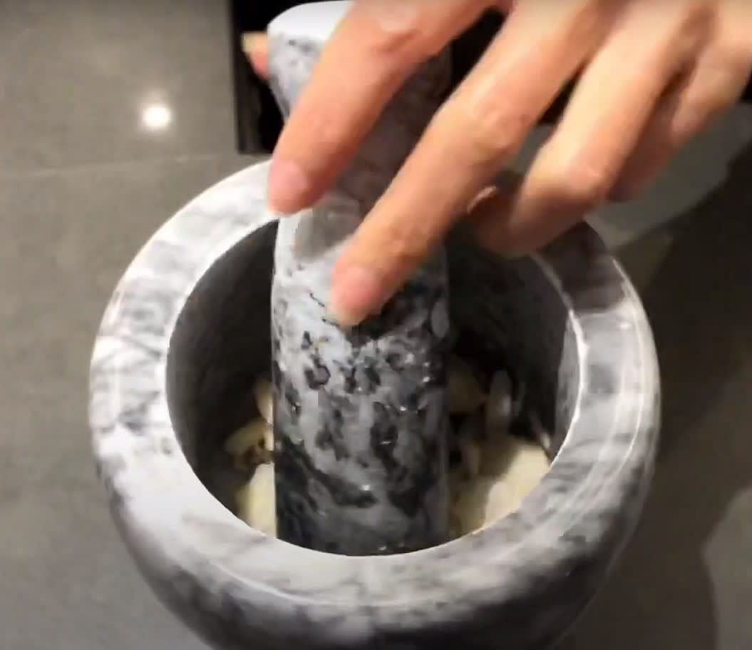 Use mortar and pestle to crush half the Galangal and half of the Red onion