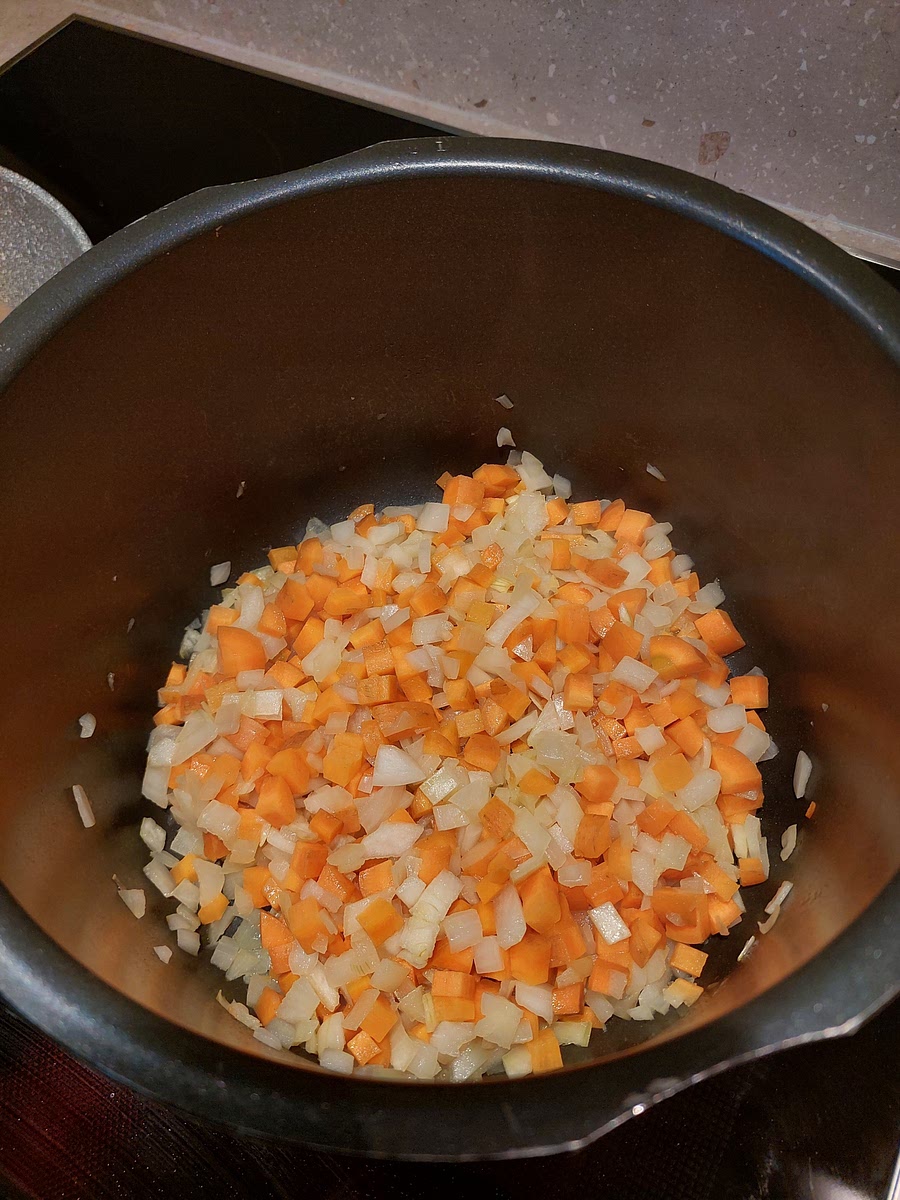 Right after you have started browning the meat, start frying the onion and carrots in a large pot with oil on medium heat. Stir occasionally in between dividing the meat with a spatula.
