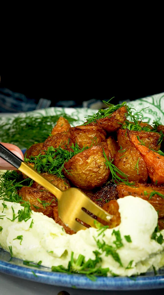 6. Spoon the whipped feta onto a serving platter, arrange the roasted potatoes on top, and garnish with the remaining chopped dill. Enjoy!