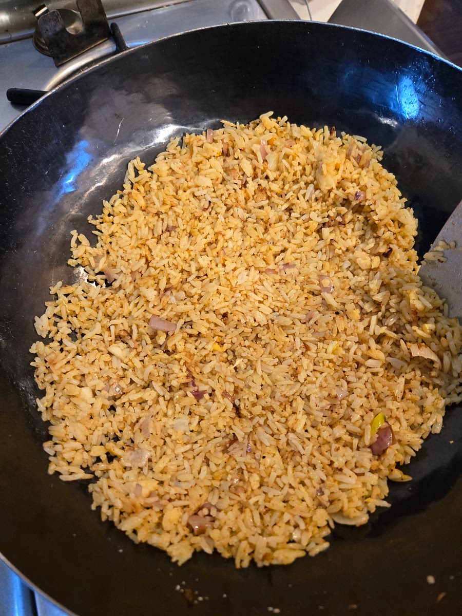 Put chopped garlic and white part of onions into hot oil. Let cook 10-20 seconds and dump rice in to oil and toss to mix. Stir fry rice until grains are separated and not sticking together when tossed. Add 1/4 tsp. MSG, toss thoroughly. add cooking wine, toss thoroughly