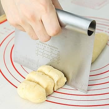 After the dough has rested, lightly knead and separate into 10 equal sized pieces. On an oiled plate, spread the naan to about 1 cm thickness.