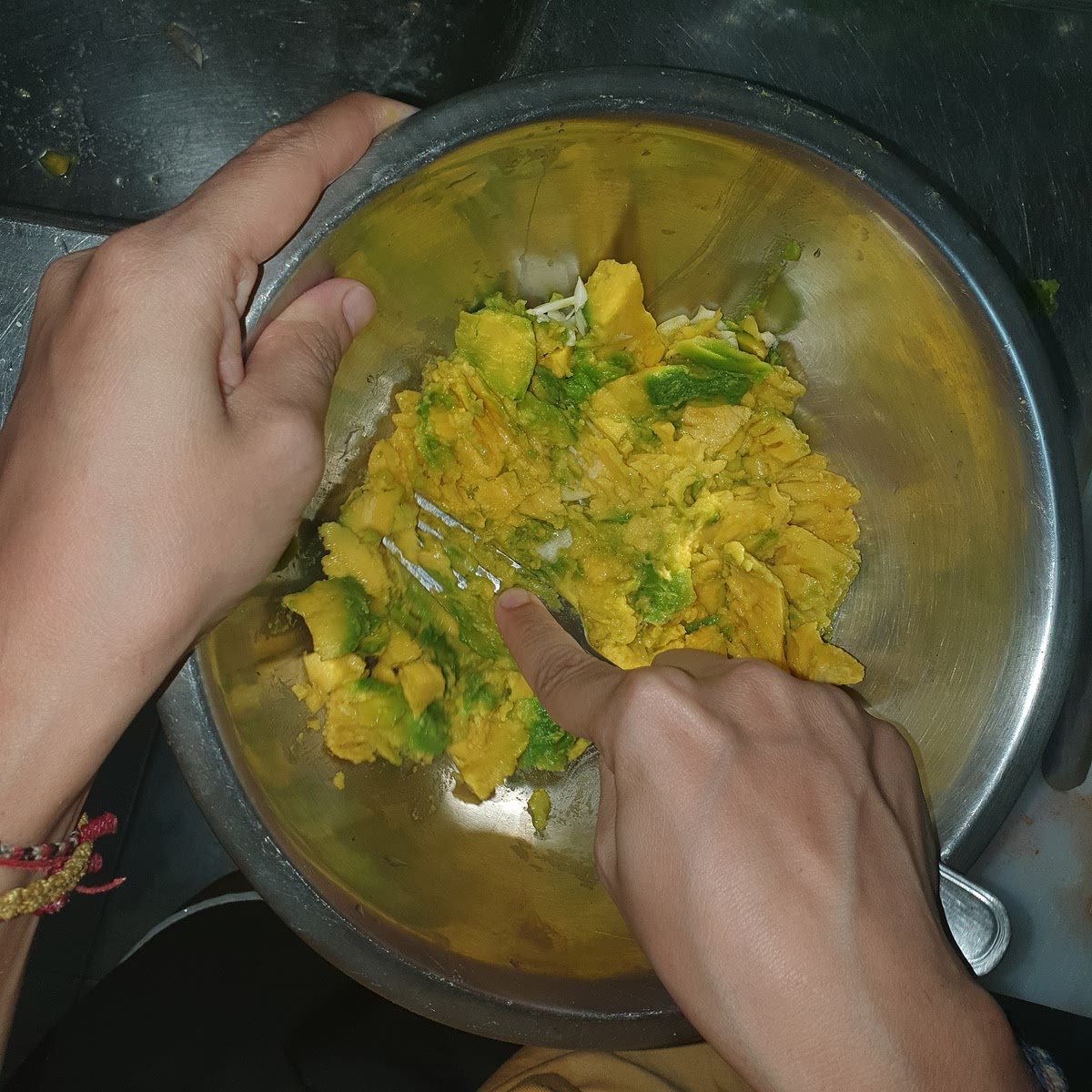 Lepel de advocado uit, doe het in een kom samen met het zout, uitgeperste sap van de halve limoen en de geperste knoflook teen. Prak en meng dit vervolgens met een vork tot een pap waarin alleen nog kleine stukjes advocado in aanwezig zijn.