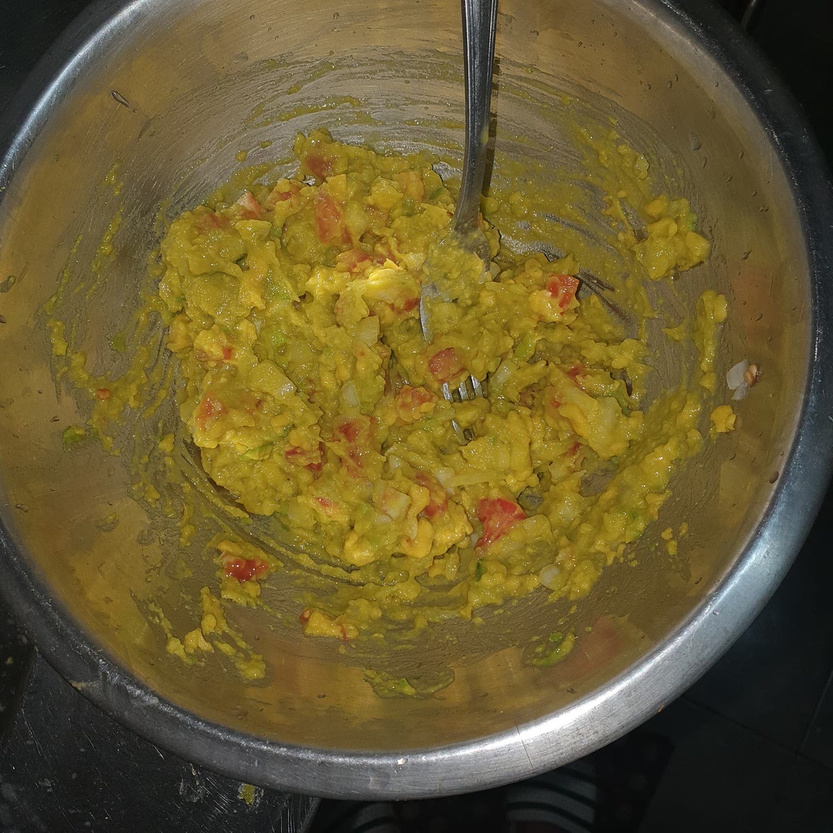 Snijd de ui en tomaat in kleine blokjes (voor ui ong 1/2 bij 1/2 cm en tomaat 2/3 bij 2/3 cm) en voeg dit toe aan de advocado pap en meng tot een geheel.