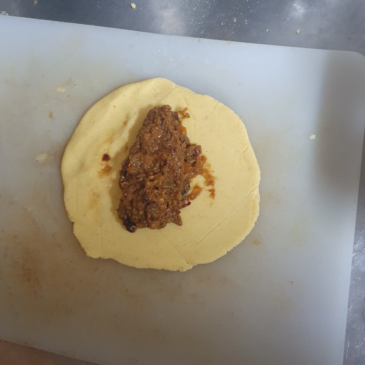 Leg ongeveer 1 tot 2 eetlepels Empanada vulling in de lengte in elke ronde deegschijf