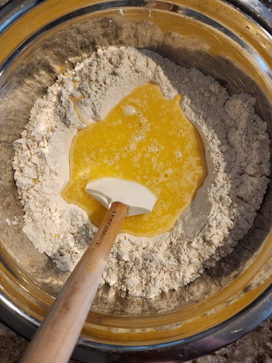Whisk together warm water and one egg in a medium bowl. Add warm milk and butter mixture and whisk until combined. Pour over flour mixture and stir until the dry for is all mixed in. The dough will start to feel too sticky to work with your hands, that is expected. Do your best to get the ingredients pulled tighter, nothing more.