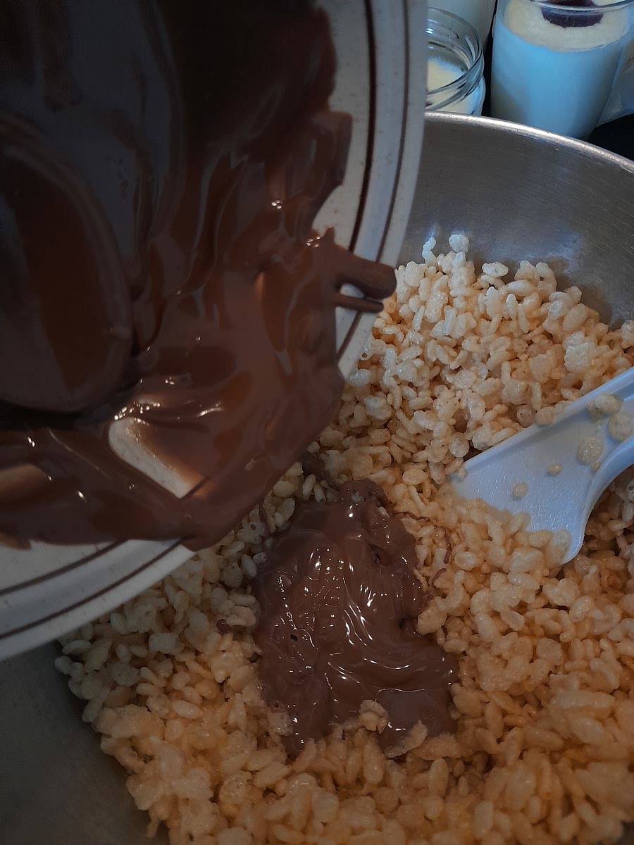Pour chocolate into Rice Crispy and stir until fully combined. If you wish to add more, go ahead! [NOTE: The more you add, the more firm they will be]