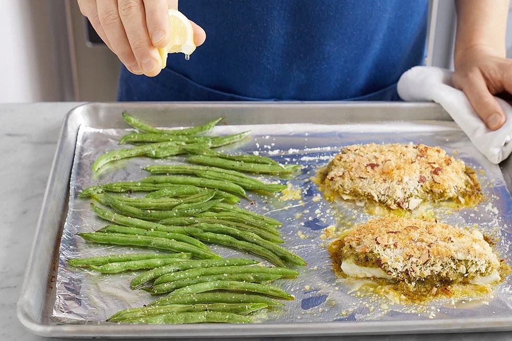 Evenly top the roasted green beans with the juice of 1 lemon wedge (you will have extra); carefully stir to coat. Serve the roasted fish with the roasted potatoes and finished green beans. Serve the reserved creamy pesto on the side. Enjoy!