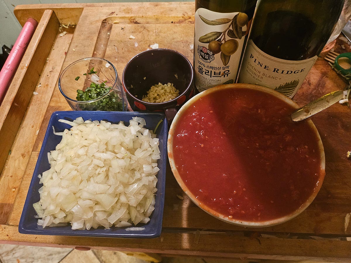 Use masher, blunt object, or wood spoon to mash tomatoes into puree, then mix in paste and any leftover liquid tomato puree from the canned tomatoes