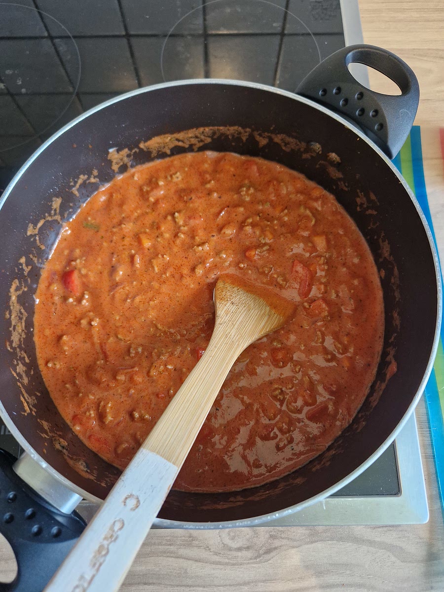 Danach mit Salz und Pfeffer würzen, 1 Dose hägehackte Tomaten mit ins Essen. Passierte Tomaten (ca 350g) nach und nach in den Topf geben. Creme Fraiche 1,5 Esslöffel, Tomatenmark, beide Ketchups jeweils ein Schuss. Pizzagewürz zum Schluss, mit Creme Fraiche und Salz und Pfeffer abschmecken.