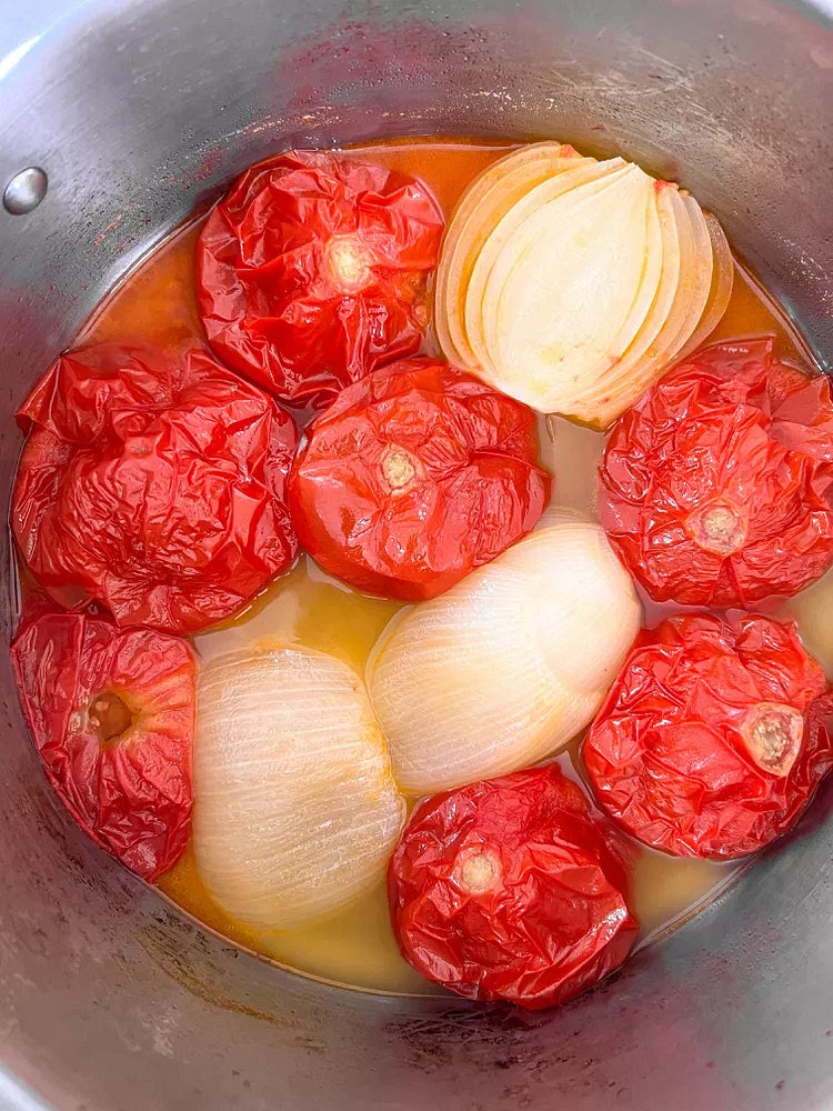 Set the pot over medium-low to low heat. Slowly cook uncovered for about 1 hour to 1 1/2 hours until the tomatoes and onions fall apart when poked with a spoon as shown in the image below. If starting with frozen tomatoes, I cover the pot with a lid for the first 30 minutes to help move the process along.
