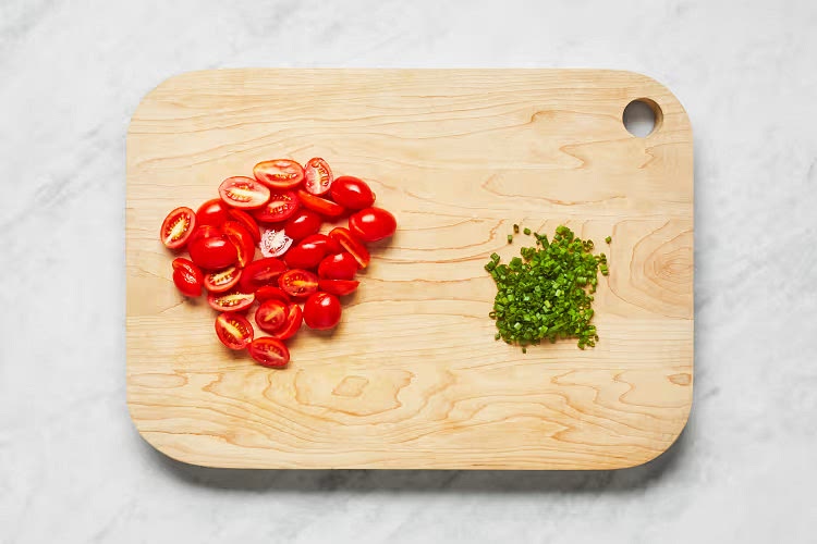 • Add 1⁄2 cup stock to pan with rice mixture; stir until liquid has mostly absorbed. Repeat with remaining stock— adding 1⁄2 cup at a time and stirring until liquid has mostly absorbed—until rice is al dente and risotto is creamy, 25-30 minutes. Season generously with salt and pepper. TIP: Depending on the size of your pan, you may need a little more or a little less liquid for the risotto. • Meanwhile, halve tomatoes. Mince chives. While risotto cooks, rinse shrimp* under cold water; pat shrimp or chicken* dry with paper towels. Season with salt and pepper. Heat a drizzle of olive oil in a second large pan over medium-high heat. Add shrimp or chicken in a single layer; cook, stirring occasionally, until cooked through, 4-6 minutes.
