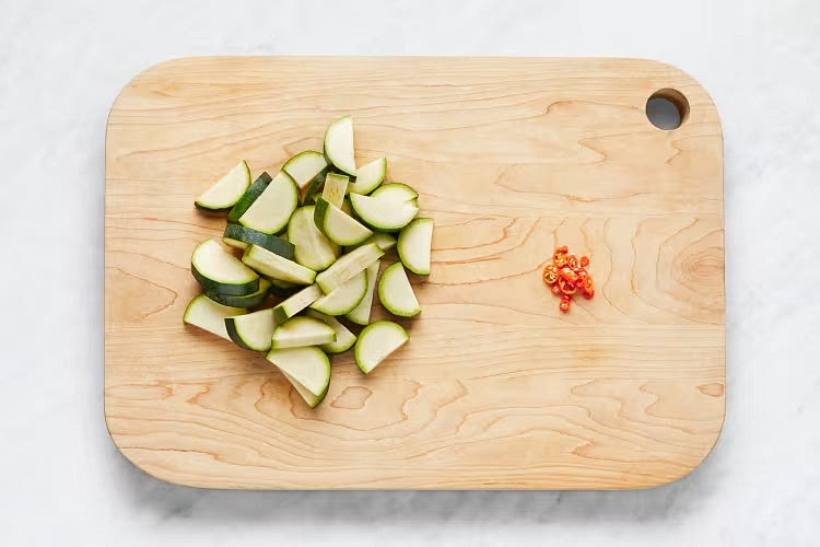 • Meanwhile, wash and dry produce. • Trim and halve zucchini lengthwise; cut crosswise into 1⁄4-inch-thick half- moons. Thinly slice chili. • Rinse shrimp* under cold water, then pat dry with paper towels.