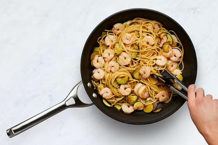• Add drained spaghetti, garlic herb butter, half the Parmesan (save the rest for serving), and 1⁄4 cup reserved pasta cooking water (1⁄2 cup for 4 servings) to pan with shrimp mixture. Season generously with salt and pepper. • Toss until everything is thoroughly combined. TIP: If needed, stir in more reserved cooking water a splash at a time until pasta is thoroughly coated in sauce.