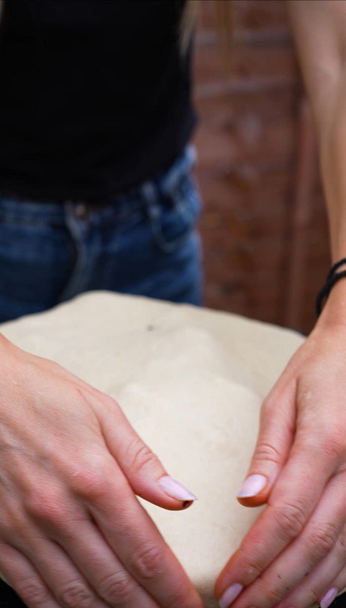 7. Roll out the dough to a size slightly larger than the skillet. Cover the skillet with the dough, then reduce the grill temperature to 220°C.