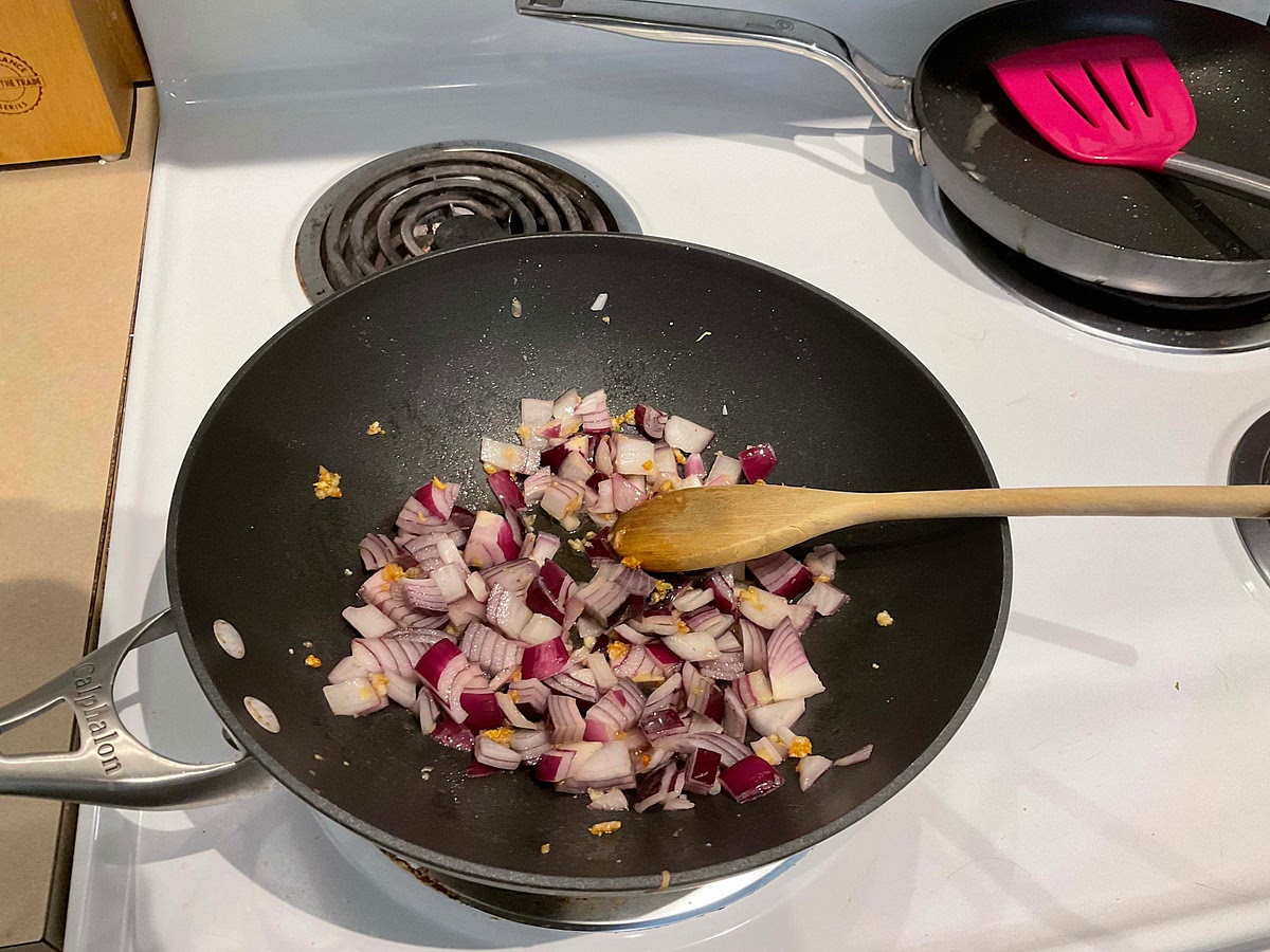 Add garlic, diced onions, and drained chickpeas into the pan and let it fry for 2-3 minutes