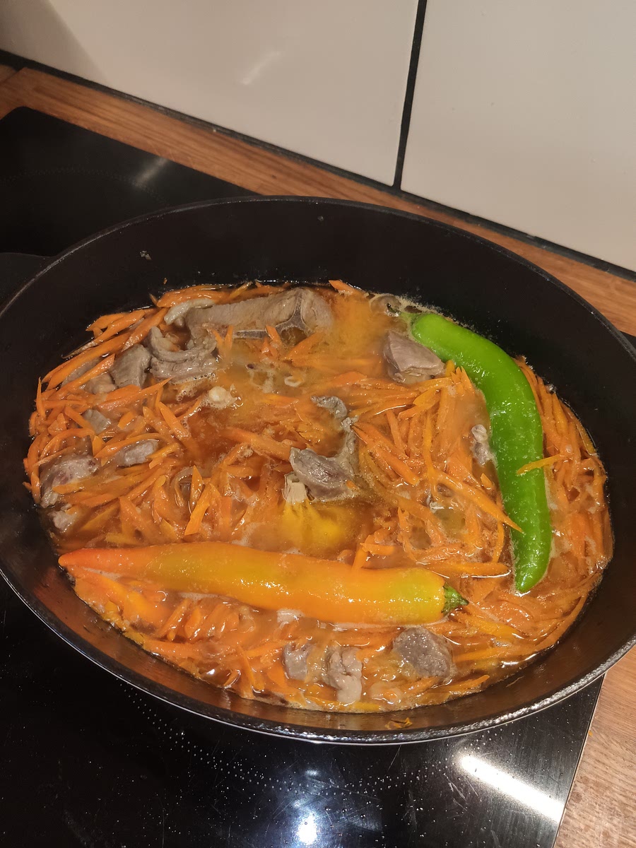 Rajouter 0,5l d'eau, les gousses d'ail entières et le 🌶, laisser cuire 40-60 minutes à feu doux.