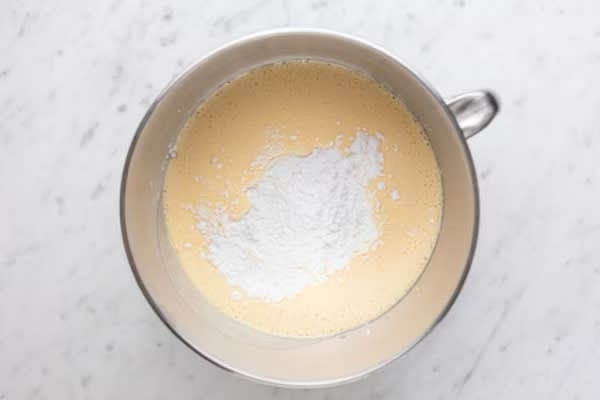 Unite lo yogurt e continuate a mescolare. Incorporate poi le polveri setacciate: la farina, la fecola di patate e il lievito per dolci. Mescolate con una spatola fino a ottenere un composto omogeneo.