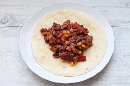 Scaldate le tortillas su una piastra e farcitele con il ripieno preparato. Ripiegate i bordi di ogni tortilla verso l'interno, quindi arrotolatela su se stessa tenendo infine la parte sovrapposta verso il basso. Tagliate a metà e servite subito i burrito di carne
