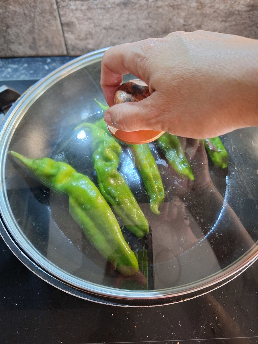 Poner los pimientos, añadir una piza de sal, y tapar.
Dejar a fuego medio durante 5 - 7 minutos, y voltear.