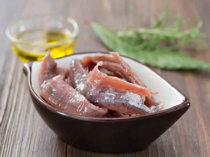 Capovolgiamo la sarda dal lato della pelle e staccare via la pinna dorsale. Adesso possiamo dividere le due metà. Laviamole più volte sotto acqua corrente e tagliamo ogni striscia in 3 pezzi.