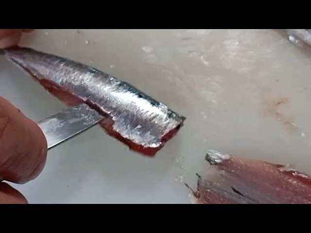 Nel frattempo che si prepara la pasta, iniziamo a pulire le sarde: si rimuove la testa e poi si taglia in lunghezza. Rimuoviamo gli interni e dopo schiacciamo con le dita per aprirla per bene "a libro", così da far risaltare la lisca. Stacchiamo la lisca tirando via anche la coda.