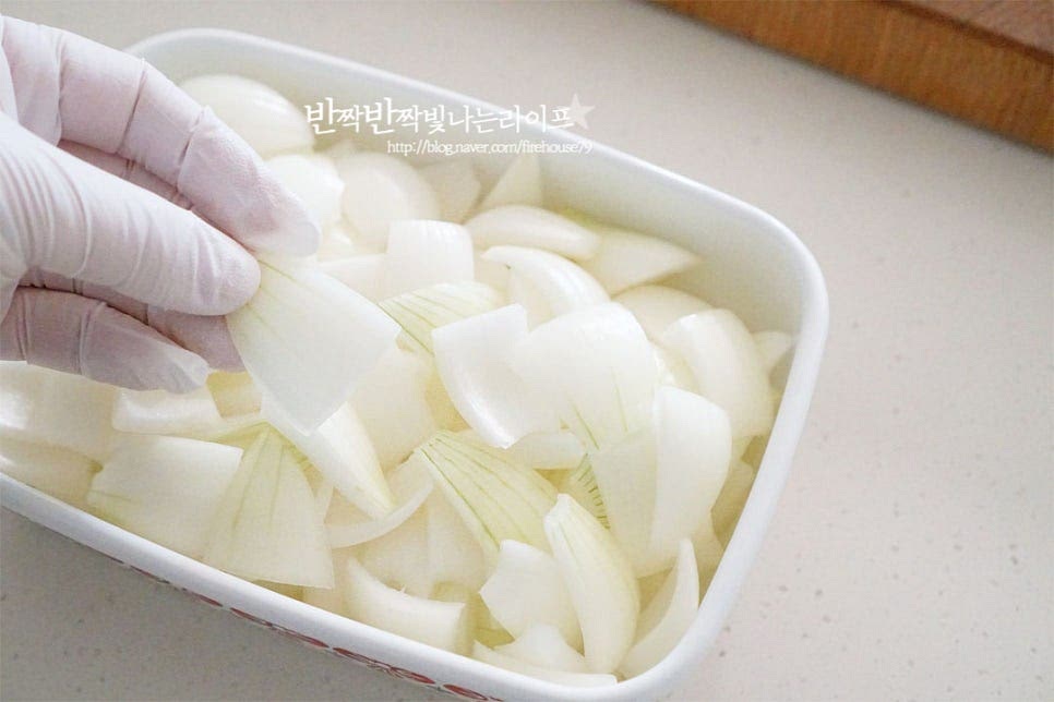 보관할 밀폐용기에 양파를 분리해서 넣어줍니다. 하나씩 뭉치지 않게 넣어주면 간이 골고루 배서 바로 만들어 먹기도 좋습니다. 고추도 함께 넣어주세요.