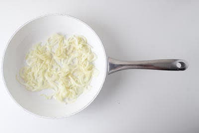 Heat a large, wide-based pan (preferably non-stick) with a drizzle of vegetable oil over a medium heat.
Once hot, add the sliced onion with a pinch of salt and cook for 5-7 min or until starting to soften.