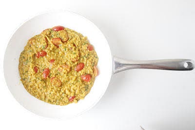 Add the halved baby plum tomatoes to the pan and cook for 5-7 min further or until the tomatoes have softened and the lentils are tender.
Stir most of the chopped coriander (save some for garnish!) through the lentils – this is your tomato & coconut dal