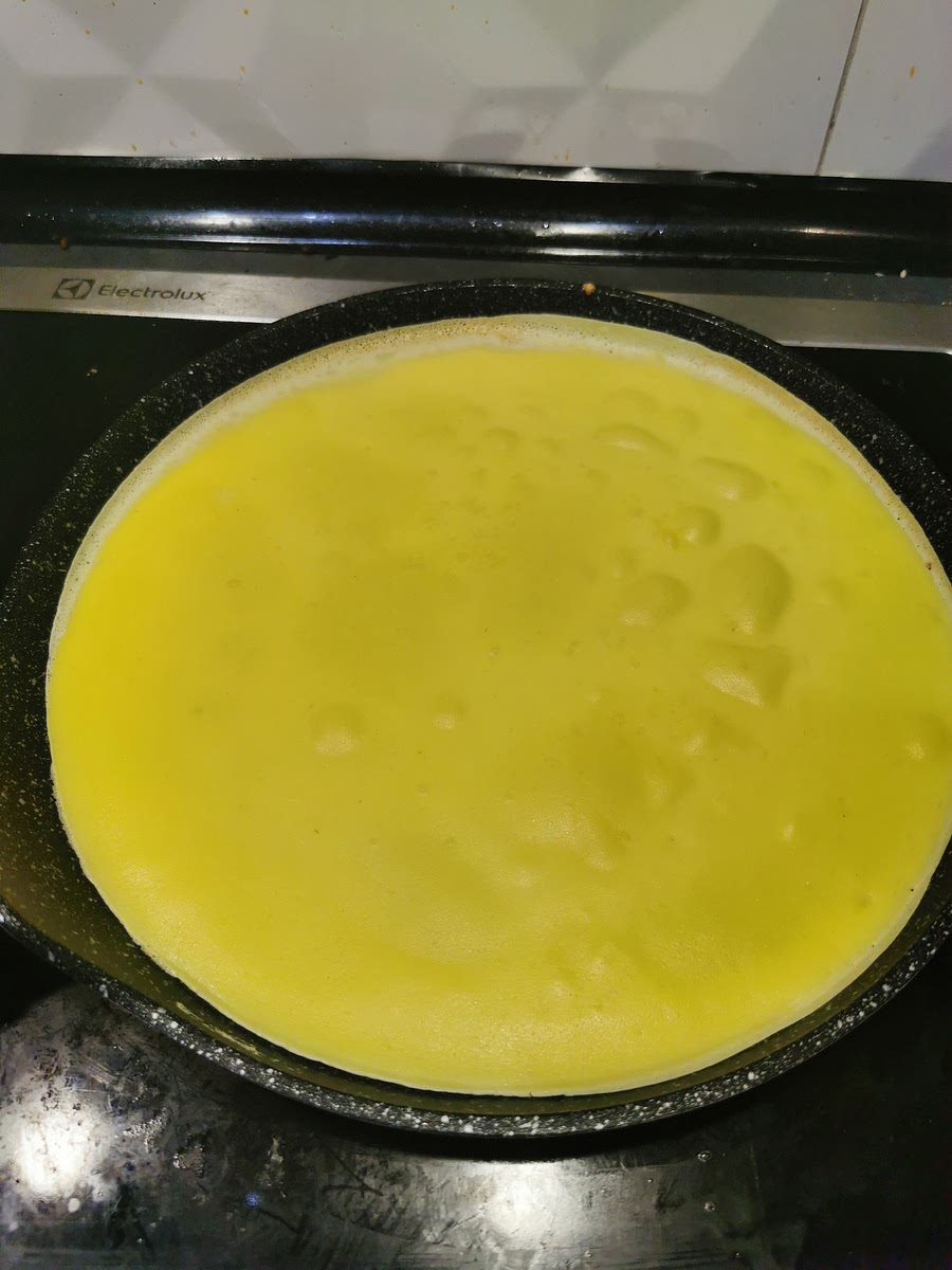 Przewróć kiedy góra całkiem się zetnie.
Najlepiej kiedy podważanie naleśnika juz go nie rozrywa.
Możesz też oczekiwać do zarumieniena się rantów.