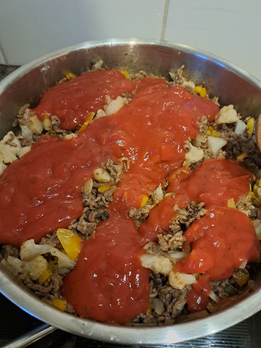 Let that cook for about 5 minutes. Then add the red lasagna sauce and mix well. Cook for another 5-10 minutes, until the vegetables are Al Dente. They don't need to be soft because they will cook once in the oven too.