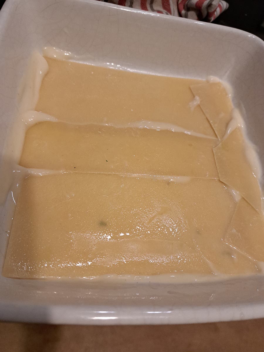 Add a spoon if white sauce on the bottom of the dish just to cover the surface.