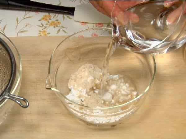 Successivamente, prepariamo la miscela di kuzu per i mochi semplici, quelli senza té matcha. Unite in una ciotola l'amido di kuzu, lo zucchero grezzo e 1/3 d'acqua.