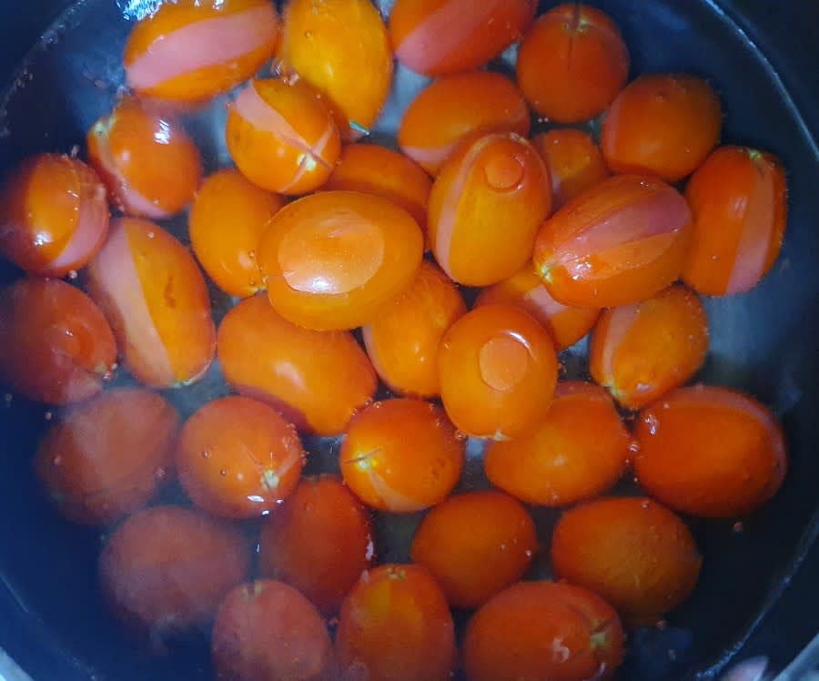 끓는물에 방울토마토를 전부 넣어 주세요. 방울토마토를 넣고 나면 끓는게 잠시 가라앉는데요, 한번 저어준 후 물이 다시 끓어오르면 불을 꺼주면 됩니다. 물이 다시 끓을때쯤 이렇게 방울토마토 껍질이 벗겨지는게 눈에 보입니다.